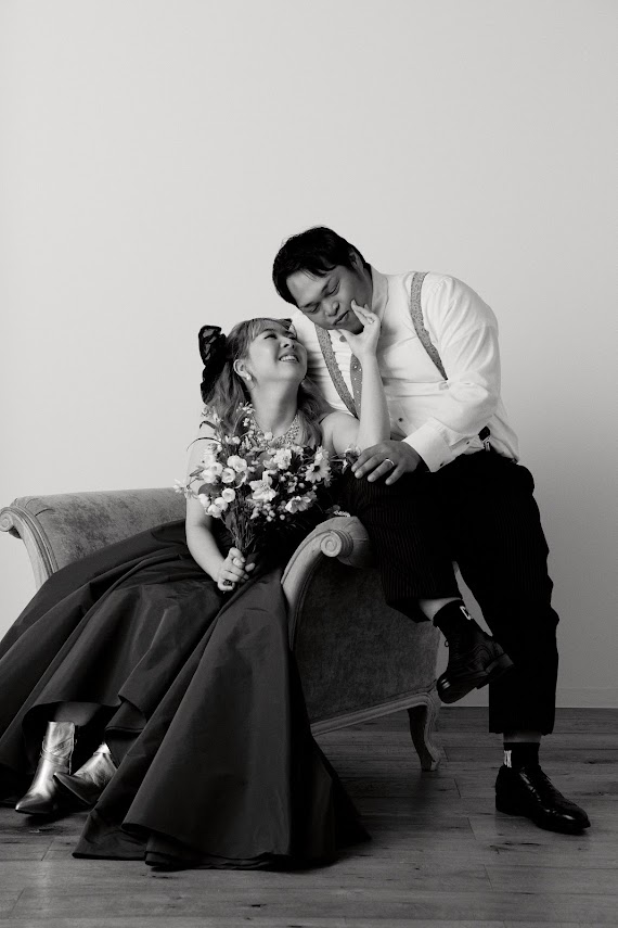 ソファに座って見つめ合う新郎新婦のモノクロ写真