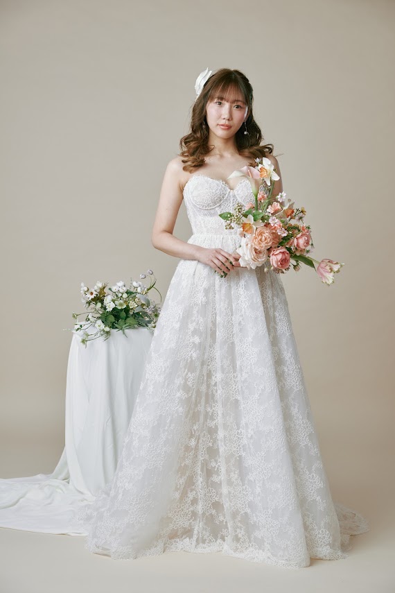 ブーケを持ったレースのウエディングドレス姿の新婦