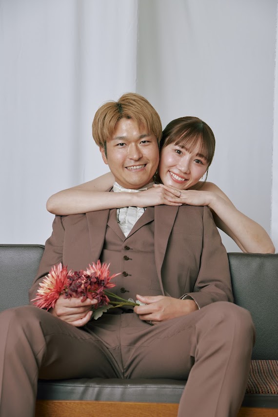 ソファで新郎に後ろから抱きつく新婦