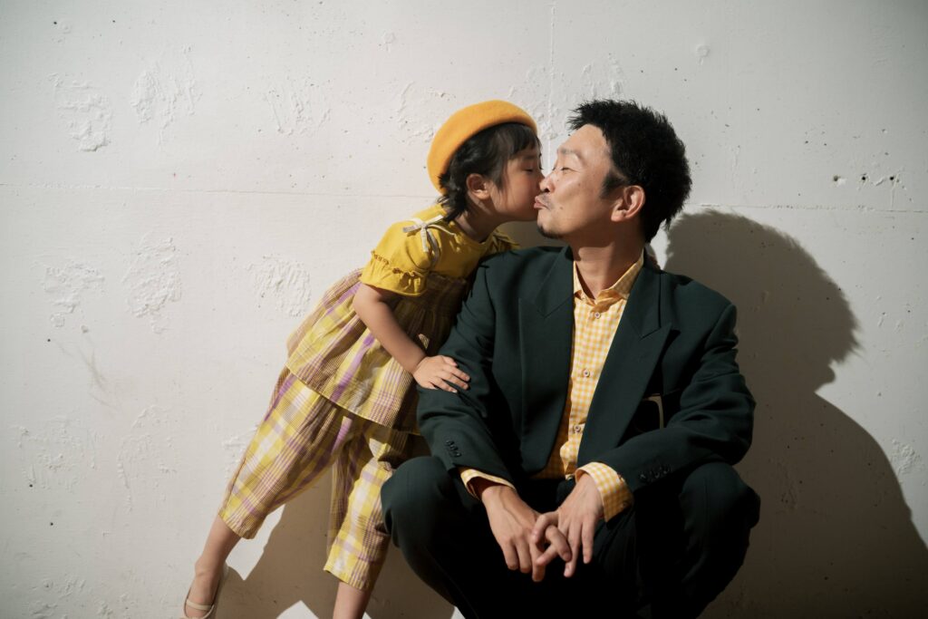 イエローを取り入れた衣装で、お父様の頬にキスをするお子様