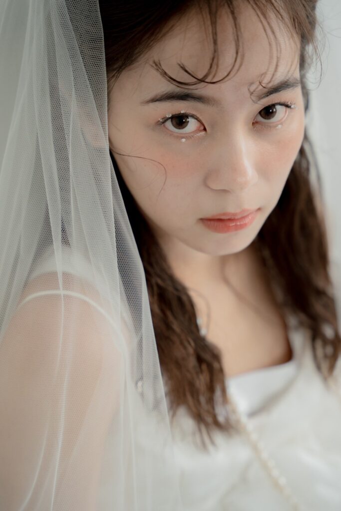 ベール越しの花嫁を写したナチュラルなブライダルヘアメイク