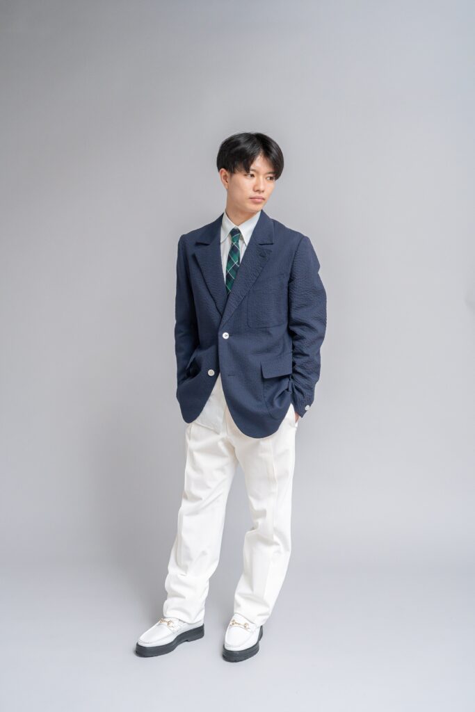 ネイビーのジャケットに白のパンツとチェック柄のネクタイを合わせた新郎
